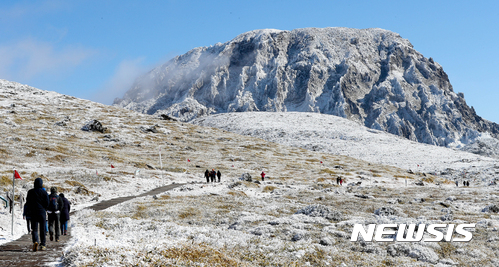 【제주=뉴시스】우장호 기자 = 수은주가 영하권으로 뚝 떨어진 19일 제주 한라산에 첫눈이 내린 가운데 등반객들이 즐거운 표정으로 눈꽃 비경을 감상하고 있다. 2017.11.18. woo1223@newsis.com