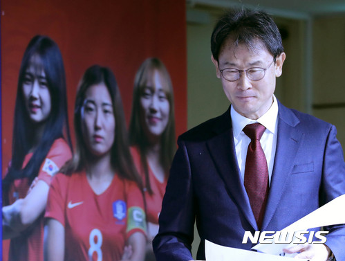 【서울=뉴시스】 여자 축구 국가대표팀 윤덕여 감독 뒤로 붉은 유니폼을 입은 선수들 사진이 보인다.