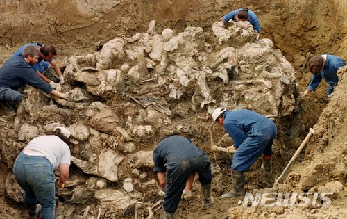 【AP/뉴시스】 보스니아 전쟁이 끝난 1년 후인 1996년 9월 국제전쟁범죄재판소 조사관들이 8000여 명의 무슬림 남자들이 단시간에 집단학살돼 여러 곳에 파묻힌 스레브레니카에서 한 매장지를 찾아 시신들을 수습하고 있다. 이 학살을 지휘한 세르비아 민병대 대장인 라드코 믈라디치가 체포된 뒤 오랜동안 재판 받아오던 유엔 유고전쟁범죄특별재판소로부터 22일 선고 언도를 앞두고 있다. 2017. 11. 21.