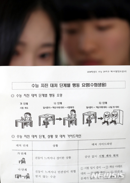 【세종=뉴시스】강종민 기자 = 포항 지진으로 연기됐던 2018 대학수학능력시험이 하루 앞으로 다가온 22일 오전 세종시 한 고등학교에서 수험생들이 수능 지진 대처 단계별 행동 요령을 살펴보고 있다. 2017.11.22. ppkjm@newsis.com