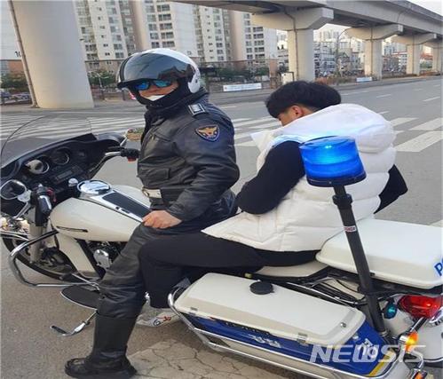 【수원=뉴시스】김도란 기자 = 2018학년도 대학수학능력시험이 치러진 23일 오전 7시 50분께 경기 용인의 한 도로에서 늦잠을 자는 바람에 지각할 위기에 처한 남학생을 경찰관이 오토바이에 태우고 있다. 이 학생은 경찰의 도움으로 5.8㎞ 떨어진 시험장 포곡고등학교에 무사히 도착할 수 있었다. 2017.11.23 (사진=경기남부지방경찰청 제공) photo@newsis.com