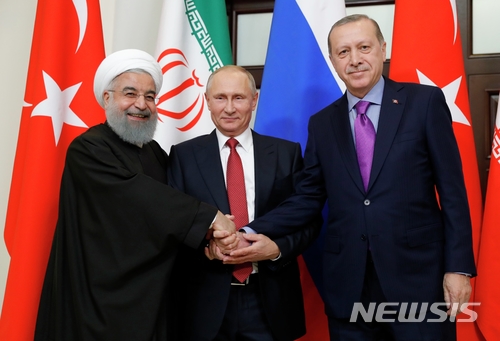 【소치=AP/뉴시스】하산 로하니 이란 대통령, 블라디미르 푸틴 러시아 대통령, 레제프 타이이프 에르도안 터키 대통령이 22일(현지시간) 러시아 소치에서 만나 손을 맞잡고 있다. 3명의 정상들은 러시아가 12월 개최할 '시리아 국민 대화 회의(Syrian national dialouge congress)'에 대한 협력에 합의했다. 2017.11.23 