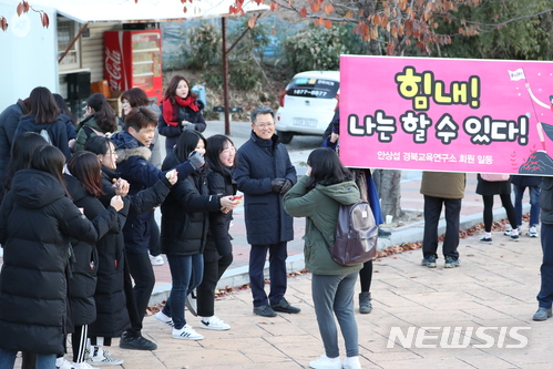 【포항=뉴시스】추상철 기자 = 2018학년도 대학수학능력시험일인 23일 오전 경북 포항시 이동고등학교에 마련된 시험장에서 수험생이 교사와 후배로 부터 격려를 받고 있다. 2017.11.23.   scchoo@newsis.com 