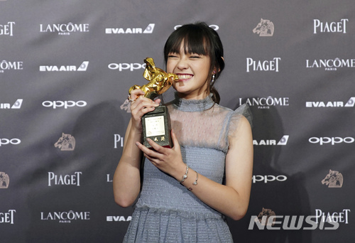 【타이베이(대만)=AP/뉴시스】대만의 14살 여배우 비키 첸(文淇)이 25일 타이베이에서 열린 54회 금마장 영화제에서 최우수 여우조연상을 수상한 뒤 트로피를 들고 기뻐하고 있다. 그녀는 영화 혈관음(血觀音, The Bold, The Corrupt, and The Beautiful)에서 성폭행 장면을 목격하고 양심에 따라 이를 증언해야 하는지, 일자리를 지키기 위해 침묵할 것인지 고민하는 호텔 메이드 역할로 출연했다. 2017.11.26