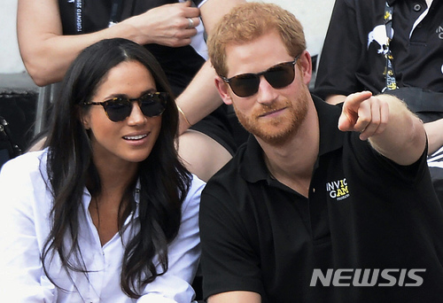 【AP/뉴시스】 올 9월25일 영국의 해리 왕자와 여자친구 메건 마크리가 캐나다 토론토에서 개최된 상이용사들의 휠체어 테니스 경기를 관람하고 있다. 미 LA 출신인 마크리는 토론토에 거주하고 있으며 이 '인빅터스 게임스'는 해리의 일생 역작이다. 27일 두 사람의 결혼 예정이 발표됐다. 2017. 11. 27.&nbsp; 