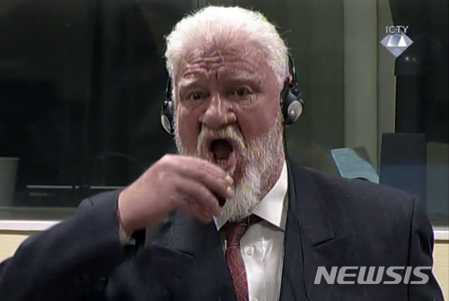 29일 유엔 전범재판 항소심에서 20년 징역형이 확정되자 피고 슬로보단 프랄작이 작은 병을 들어마시고 고함을 질렀다. AP. 