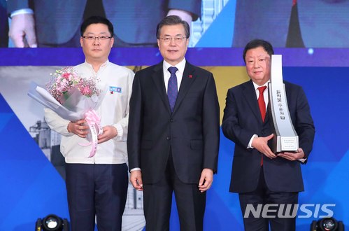 【서울=뉴시스】전신 기자 = 문재인 대통령이 5일 서울 삼성동 코엑스에서 열린 제54회 무역의 날 기념식에서 전인장 삼양식품 대표이사에게 수출의 탑을 수여하고 있다. 2017.12.05. photo1006@newsis.com