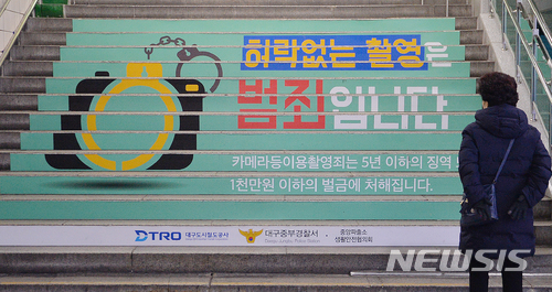 【대구=뉴시스】우종록 기자 = 6일 오전 대구시 중구 지하철 1호선 중앙로역 계단에 '허락없는 촬영은 범죄입니다'라고 적힌 몰카 예방 홍보문구가 지나는 시민의 눈길을 끌고 있다. 2017.12.06. wjr@newsis.com