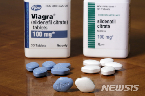 【뉴욕=AP/뉴시스】지난 4일 미 뉴욕의 제약회사 화이자 본사에 발기부전치료제 비아그라(왼쪽 푸른색 알약)와 자체 복제약 실데나필(오른쪽 흰색 알약)이 놓여 있다. 파이자의 독점판매권이 오는 11일 종료됨에 따라 파이자는 자체 복제약 실데나필을 현 비아그라의 절반 가격에 출시하기로 했다. 2017.12.7