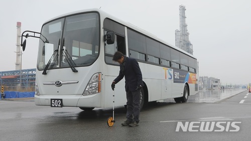 【서울=뉴시스】교통안전공단이 지난 7일 상주 교통안전체험교육센터에서 진행한 '빙판길 교통사고 위험성 실험'에서 공단 소속 박승호 교수가 버스와 승용차 제동거리를 측정하고 있다. (제공=교통안전공단)