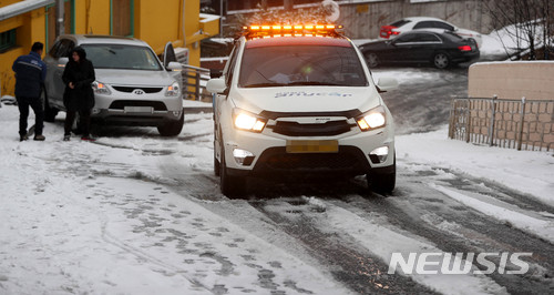 【서울=뉴시스】추상철 기자 = 새벽에 많은 눈이 내린 10일 오전 서울 용산구 주택가에서 견인차가 빙판길에 미끄러진 차량 견인작업을 하고 있다. 2017.12.10. scchoo@newsis.com