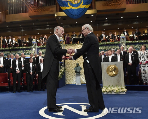  【 스톡홀름=AP/뉴시스】노벨상 생리의학상 공동수상자인 마이클 로배시 미국 브랜다이스대 교수가 11일(현지시간) 스웨덴 스톡홀름 시청에서 열린 시상식에서 칼 구스타브 16세 국왕으로부터 메달을 받고 있다. 2017.12.11 