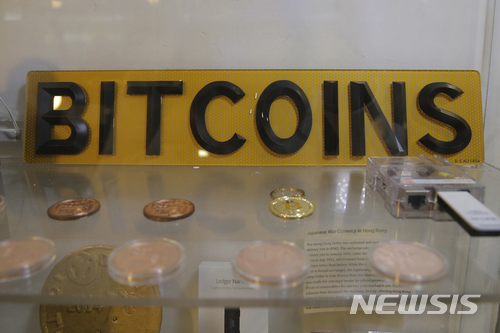 【홍콩=AP/뉴시스】 8일 홍콩에서 가상화폐 비트코인의 ATM 기 옆에 코인과 표시판이 전시되어 있다. 홍콩은 이 현금자동지급기로 가상화폐를 사용하고 있고 10일 미국에서 비트코인의 선물시장 거래가 시작됐다. 2017. 12. 11. 