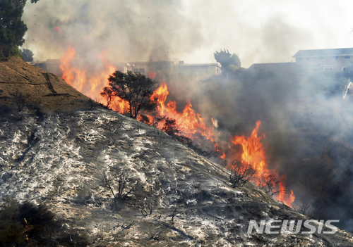 【로스앤젤레스 = AP/뉴시스】 = 지난 주 6일(현지시간) 로스앤젤레스의 벨 에어지구의 계곡 능선을 따라 거세게 타고 있는 산불.&nbsp; 소방 당국은 12일 이 불의 원인이 인근 노숙자 캠프에서 불법 취사를 위해 피운 불이 번진 탓이라고 발표했다.&nbsp;&nbsp; 