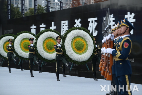 【난징=신화/뉴시스】 중국 난징대학살 80주년 기념일인 13일 장쑤성 난징시 '난징대학살 희생자 기념관'에서 국가 주도 추모식이 열리는 가운데 군인들이 추모화환을 옮기고 있다.&nbsp; 2017.12.13