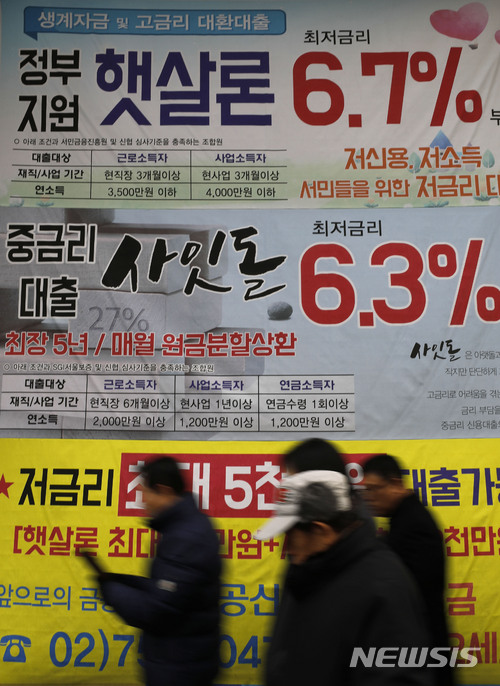 【서울=뉴시스】최동준 기자 = 지난 2017년 시민들이 서울 시내 한 금융기관 대출 광고 현수막 앞을 지나가고 있다. 2017.12.14. photocdj@newsis.com