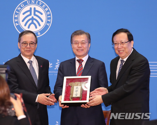 【베이징(중국)=뉴시스】전진환 기자 = 중국을 국빈방문한 문재인 대통령이 15일 오전(현지시각) 중국 베이징대학교에서 '한중 청년의 힘찬 악수, 함께 만드는 번영의 미래'를 주제로 연설을 마치고 베이징대 하오핀(오른쪽) 당서기로부터 베이징대의 옛날 이름인 '대학당'이라고 쓰인 명패를 전달받고 있다. 왼쪽은 린젠화 베이징대 총장. 2017.12.15.&nbsp; amin2@newsis.com 