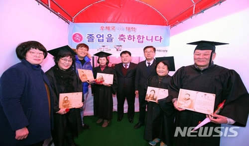 【대구=뉴시스】배소영 기자 = 경북지방우정청은 18일 경주 안강우체국에서 ‘우체국 작은 대학 제 1기 졸업식‘을 열고 졸업생들과 기념사진을 촬영하고 있다. 2017.12.18. (사진=경북지방우정청 제공)photo@newsis.com