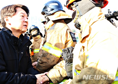 【제천=뉴시스】강신욱 기자 = 22일 오전 충북 제천시 화소동 한 스포츠센터 건물 화재 현장을 찾은 안철수 국민의당 대표가 진화 활동을 하는 소방관을 격려하고 있다. 이 복합건축물은 전날 오후 3시53분께 발생한 불로 29명이 숨지고 29명이 다쳤다. 2017.12.22. ksw64@newsis.com 