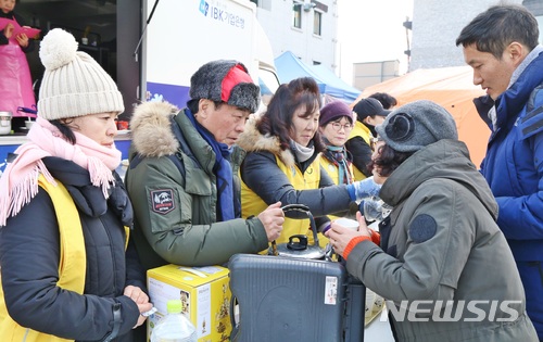 【제천=뉴시스】강신욱 기자 = 22일 충북 제천시 하소동 한 복합건축물 화재 현장 앞에서 제천시종합자원봉사센터 회원들이 따끈한 차 등을 대접하고 있다. 2017.12.22. ksw64@newsis.com