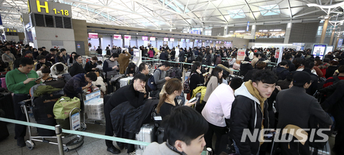 【인천공항=뉴시스】최진석 기자 = 짙은 안개로 어제부터 인천국제공항 항공기 운항 차질이 계속 이어지고 있는 24일 오전 인천국제공항 출국장에서 탑승객들이 줄지어 탑승수속을 기다리고 있다. 2017.12.24.&nbsp; myjs@newsis.com
