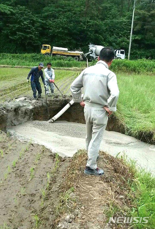 【장성=뉴시스】이창우 기자 = 사진은 지난 6월8일 전남 장성군 황룡면 와룡리 건동광산 인근 농경지에서 대형 지반침하(싱크홀)가 발생한 이후 고려시멘트 측이 레미콘과 펌프카를 동원해 몰타르(시멘트와 모래를 섞은 물질)를 강제 주입해 빈 공간을 메우고 있는 현장 모습. 2017.12.27 (사진=주민대책위 제공) lcw@newsis.com