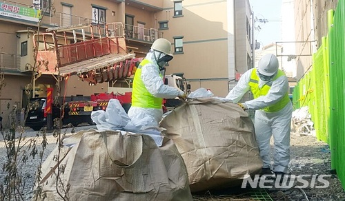 【제천=뉴시스】강신욱 기자 = 충북 제천시는 28일 하소동 스포츠센터 화재 현장에서 화재 악화의 원인으로 지목된 외장재 드라이비트를 제거해 수거하고 있다. 2017.12.28. ksw64@newsis.com