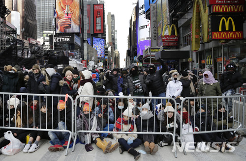 Spectators gather ahead of the New Year's Eve celebration in Times Square in New York, on Sunday, Dec. 31, 2017. New Yorkers, celebrity entertainers and tourists from around the world will pack into Times Square for what's expected to be a flashy but frigid celebration marking the start to the new year. (AP Photo/Peter Morgan)