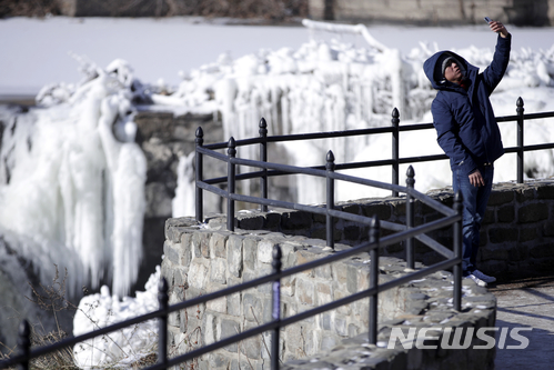 【 패터슨=AP/뉴시스】미국 뉴저지주 패터슨에 있는 패터슨 대폭포 국립역사공원에서 2일(현지시간) 한 남성이 혹한에 얼어붙은 폭포를 배경으로 사진을 찍고 있다. 2018.01.03
