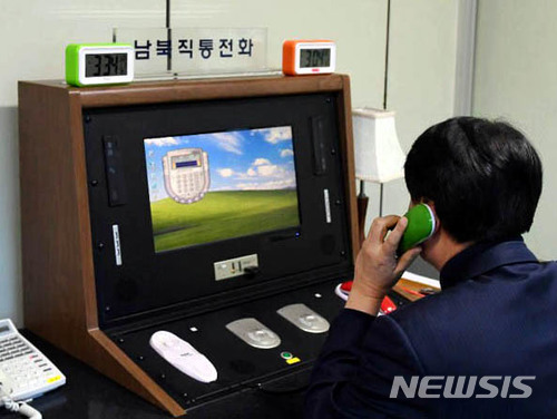 【서울=뉴시스】개성공단 가동 중단 이후 완전히 끊겼던 남북 연락채널이 1년 11개월만에 복구된 지난 1월3일 오후 3시 34분 경기 파주시 판문점 공동경비구역(JSA) 내 연락사무소에 우리측 연락관이 '남북직통전화'를 통해 북측과 통화하고 있다. 상단에 서울표준시(3시34분)와 평양표준시(3시4분)가 표시된 시계가 2개 놓여 있다. 2018.01.03. (사진=통일부 제공)photo@newsis.com