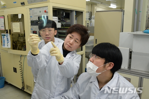 【대전=뉴시스】 2차원 나노시트가 코팅된 고분자 필름의 투과성을 관찰하는 ETRI 연구진.