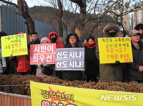 【시흥=뉴시스】이종일 기자 = 경기 시흥시 배곧신도시총연합회, 목감지구입주자대표회의 총연합회, 은계지구예비입주자대표회의 총연합회 등 3개 단체 회원들이 9일 시흥시청 정문 앞에서 집회를 열고 "버스 노선 개편으로 지옥버스 해결하라"고 촉구하고 있다. 2018.01.09. lji22356@newsis.com