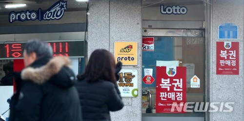 【서울=뉴시스】고범준 기자 = 작년 로또복권이 하루 평균 104억 원어치나 팔려 역대 가장 많았던 것으로 집계된 10일 오후 서울의 한 복권방 앞으로 시민들이 지나가고 있다. 2018.01.10. bjko@newsis.com
