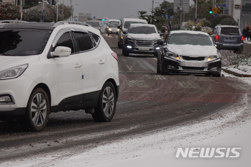 【제주=뉴시스】강정만 기자 = 폭설이 내리는 11일 아침 제주시 번화가인 신제주 로터리를 운행하는 차량들이 거북이 운행을 하고 있다. 2018.01.11.&nbsp; kjm@newsis.com