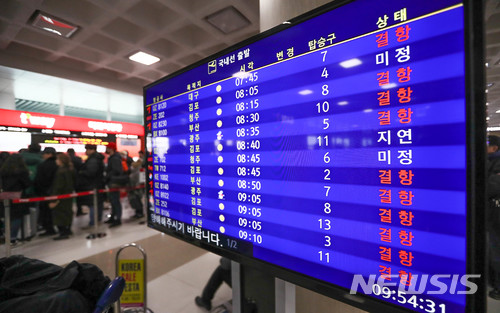 【제주=뉴시스】우장호 기자 = 11일 제주국제공항 활주로가 이날 오전 11시까지 제설작업을 위해 잠정 폐쇄된 가운데 항공기 출도착 상황을 알리는 정보판에 결항을 의미하는 빨간색 글씨가 선명하다. 2018.01.11.woo1223@newsis.com