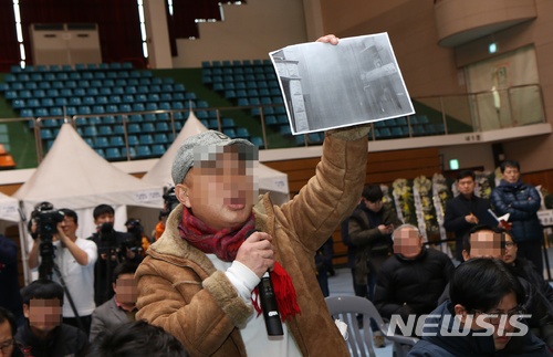 【제천=뉴시스】강신욱 기자 =&nbsp; 11일 오후 충북 제천체육관 합동분향소에서 한 유족이 소방청 합동조사단의 하소동 스포츠센터 화재 참사 조사 발표에 관련 사진을 들어보이며 강하게 반박하고 있다. 2018.01.11. ksw64@newsis.com
