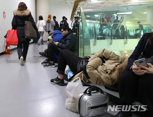 【제주=뉴시스】조수정 기자 = 올들어 제주지역에 최강 한파가 몰아친 11일 오후 제주국제공항에서 항공기 결항으로 이용객들이 쪽잠을 청하고 있다. 이날 제주국제공항은 폭설과 한파로 오전 8시 33분부터 활주로가 임시 폐쇄됐다가 약 네시간만인 12시 22분 운영이 재개됐다. 2018.01.11.&nbsp;&nbsp; chocrystal@newsis.com