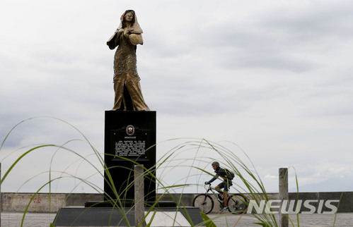【마닐라=AP/뉴시스】 지난 11일 필리핀 수도의 태평양만 부근에 건립된 필리핀 일본군 위안부 기념비 옆을 사이클리스트가 지나가고 있다. 지난해 12월8일 건립된 이 필리핀 위안부 '기림비'를 두고 10일 방문한 일본 여성 내정장관이 두테르테 필리핀 대통령에게 불쾌함과 유감을 표한 것으로 알려졌다. 2018.01.18.