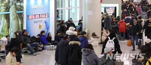 【제주=뉴시스】조수정 기자 = 올들어 제주지역에 최강 한파가 몰아친 11일 오후 제주국제공항에서 항공기 결항 및 지연 등으로 이용객들이 바닥에 앉아 운항을 기다리고 있다.&nbsp; 이날 제주국제공항은 폭설과 한파로 오전 8시 33분부터 활주로가 임시 폐쇄됐다가 11시 50분께 다시 운영시작했고 항공편은 약 네시간만인 12시 22분 운항이 재개됐다.&nbsp; 제주공항공사는 오후 4시 기준 이날 운항 예정이던 411편(국제선 도착10 출발 11, 국내선 도착 196 출발 194)의 항공편 중 국내결항 146편(도착 74, 출발 72), 국내지연 78편(도착 29, 출발 49), 국제지연 8편(도착5, 출발3), 국내선 도착 13편이 회항했다고 밝혔다. 또 4시기준 공항 체류객은 5200명으로 집계했다. 2018.01.11.&nbsp;&nbsp; chocrystal@newsis.com