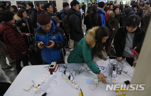 【제주=뉴시스】우장호 기자 = 제주 지역에 매서운 한파가 몰아친 12일 제주국제공항 체류객들이 스마트폰 무료충전소 앞에서 자신의  순서를 기다리고 있다. 이날 제주공항에는 한국공항공사 추산 3000여명의 체류객에 공항 내에 머물렀다. 2018.01.11.woo1223@newsis.com