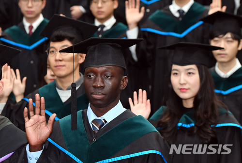 【부산=뉴시스】 하경민 기자 = 고 이태석 신부가 남수단 톤즈에서 미사를 봉헌할 당시 신부를 돕는 복사를 맡았던 청년이 한국에서 6년 간의 의과대학 생활을 마치고 히포크라테스 선서를 했다.15일 부산 부산진구 인제대 의과대학 강당에서 열린 '제34회 학위수여식'에 참가한 토마스 타반 이콧(33)씨가 동료 학생 107명과 함께 히포크라테스 선서를 하고 있다. 2018.01.15. yulnetphoto@newsis.com