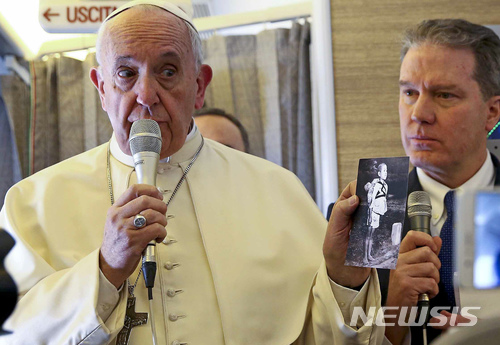 【AP/뉴시스】프란치스코 교황이 15일(현지시간) 칠레와 페루 등 남미순방에 나선 비행기 안에서 나가사키 원자폭탄 피해자의 사진을 들며 핵전쟁에 대한 우려를 표하고 있다. 2018.01.16