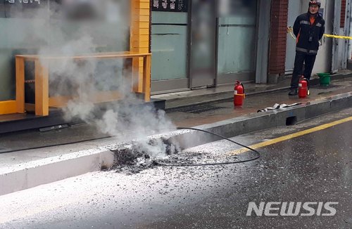 【부산=뉴시스】 하경민 기자 = 17일 오전 9시 49분께 부산 남구 못골로의 한 도로변 전신주에서 고압전선(1만3200볼트)이 끊어져 보도블럭에 떨어졌다. 사고 당시 인근을 지나는 시민이나 차량이 없어 다행히 피해는 없었지만 끊어진 전선에서 스파크가 발생해 보도블럭 일부가 타면서 파손되고, 인근 상가와 주택 등 690가구가 정전이 됐다가 1시간 만에 전기공급이 재개됐다. 2018.01.17. (사진=부산소방본부 제공) yulnetphoto@newsis.com 