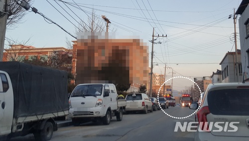 【제천=뉴시스】강신욱 기자 = 19일 오후 5시3분께 충북 제천의 한 학교에서 화재 신고를 받고 출동한 제천소방서 소방차량이 교문이 굳게 잠겨 진입하지 못한 채 대기하고 있다(원안 사진). 주변 도로 양쪽에는 여전히 불법 주·정차 차량으로 가득하다. 2018.01.19. (사진=독자 제공) photo@newsis.com