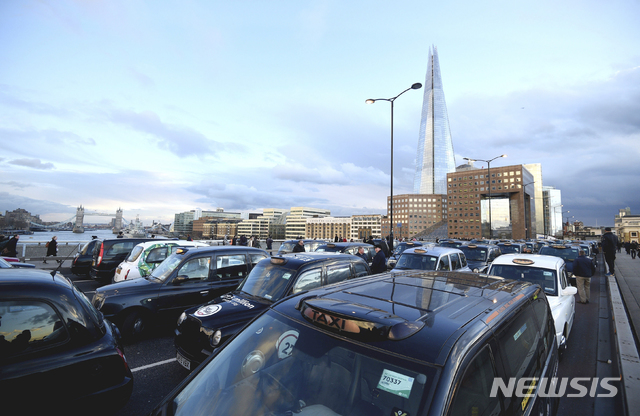 【런던=AP/뉴시스】 차량 공유 서비스 기업 우버(Uber)가 오는 2025년까지 영국 런던의 우버 차량을 전기자동차로 전환하는 것을 돕기 위해 2억 파운드(약 2950억원)를 투자할 계획이다. 사진은 런던에서 우버 영업 확산에 반대하는 기존의 택시 운전자들이 시위를 벌이는 모습. 2018.10.23