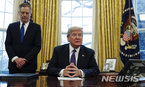 【워싱턴=AP/뉴시스】도널드 트럼프 미 대통령과 로버트 라이트하우저(왼쪽) 미 무역대표부(USTR) 대표가 23일 백악관 오벌오피스에서 태양광 패널 및 세탁기에 관세를 부과하는 세이프가드에 서명하기 전 기자들을 기다리고 있다. 월 스트리트 저널(WSJ)은 미국의 관세 부과 결정은 라이트하우저가 협상 대신 규제에 초점을 맞추기로 했음을 보여주는 것으로 앞으로 미국과 중국 간 충돌이 확산될 것이라고 내다봤다. 2018.1.24