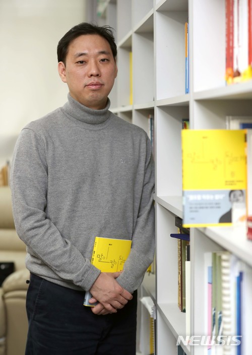 【서울=뉴시스】박진희 기자 = '말이 칼이 될때' 저자 홍성수 교수가 지난 22일 서울 용산구 숙명여대 연구실에서 인터뷰를 마치고 자신의 저서를 소개하고 있다. 2018.01.24.pak7130@newsis.com