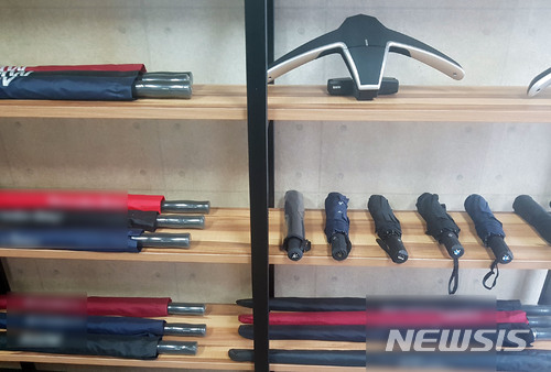 【부산=뉴시스】 하경민 기자 = 부산 동래경찰서는 29일 고급 외제승용차 브랜드를 도용한 점퍼, 우산 등 기념품과 액세서리 등을 250억원 어치를 제조해 전국의 자동차 판매사원에게 공급한 도·소매업자 A(35·여)씨와 공급책 B(41)씨, 제조책 C(52)씨 등 모두 6명을 상표법 위반 혐의로 불구속 입건했다고 밝혔다. 사진은 경찰이 압수한 수입차 브랜드 위조 우산. 2018.01.29. (사진=동래경찰서 제공)yulnetphoto@newsis.com
