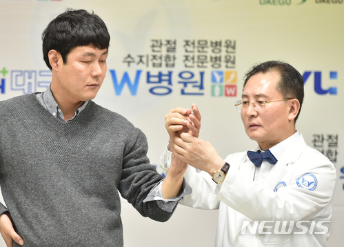 【대구=뉴시스】우종록 기자 = 국내 최초로 팔 이식 수술을 집도한 우상현 병원장이 2일 오전 대구 달서구 감삼동 W병원 10층 송원홀에서 열린 '국내 최초 팔 이식 수술 1주년 기념 경과 설명회'에서 이식한 팔을 살펴보고 있다. 2018.02.02.&nbsp; wjr@newsis.com 