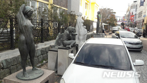 【광주=뉴시스】배동민 기자 = 광주 동구 예술의 거리에 설치된 조각상들이 오히려 도시 미관을 해치는 애물단지로 전락하고 있다. 조각상 앞에 불법주차된 차량 때문에 포토존 기능조차 하지 못하고 있다. 2018.02.04. guggy@newsis.com